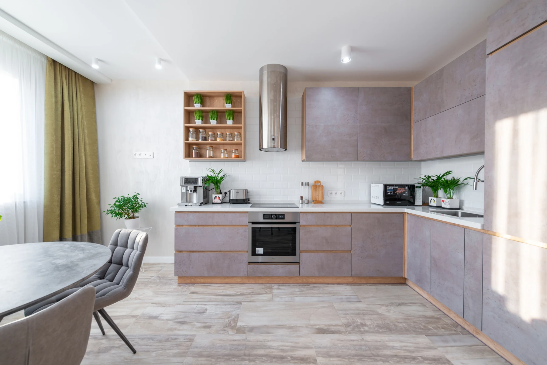 Illustrative apartment kitchen with an oven, cooktop and dining table
